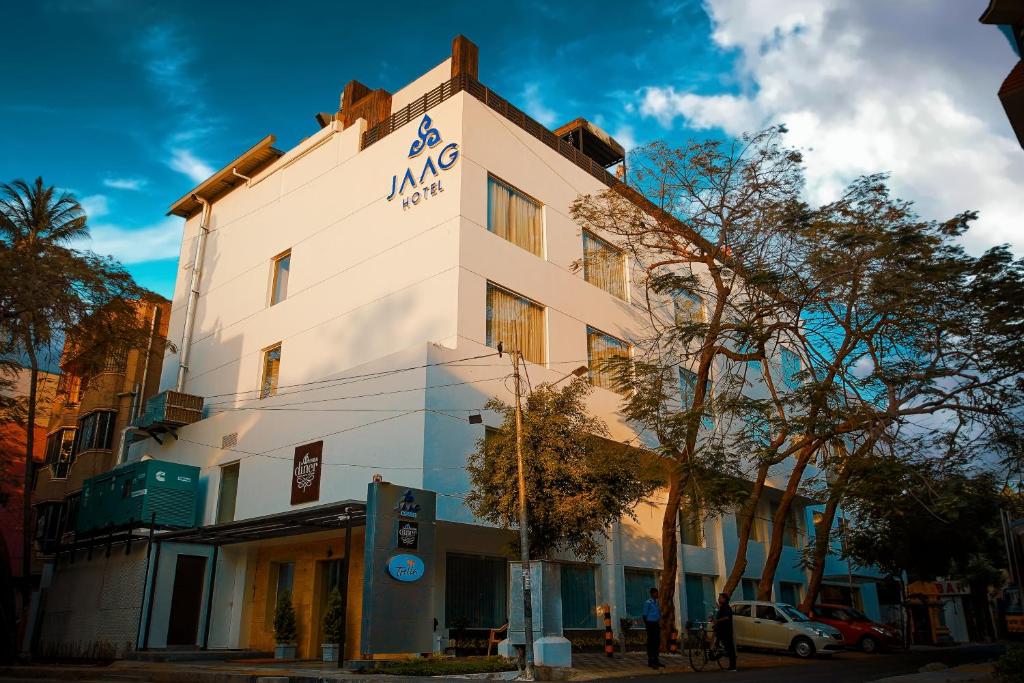 een wit gebouw met een bord aan de zijkant bij Jaag Hotel in Chennai