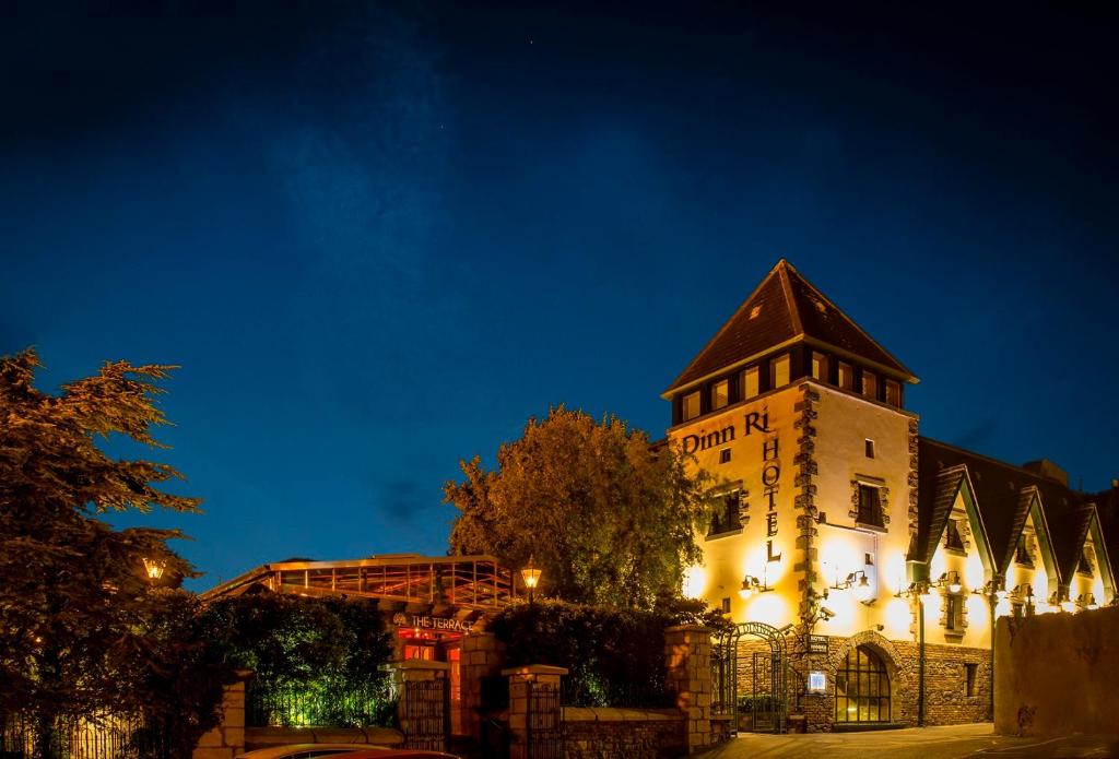 a building with a clock tower at night at Dinn R&iacute; Hotel in Carlow