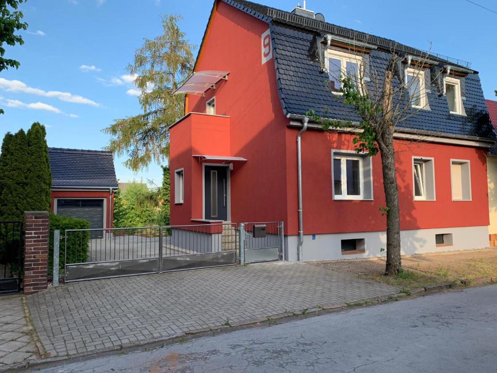 una casa rossa con tetto nero di Haus an den Elbwiesen a Lutherstadt Wittenberg