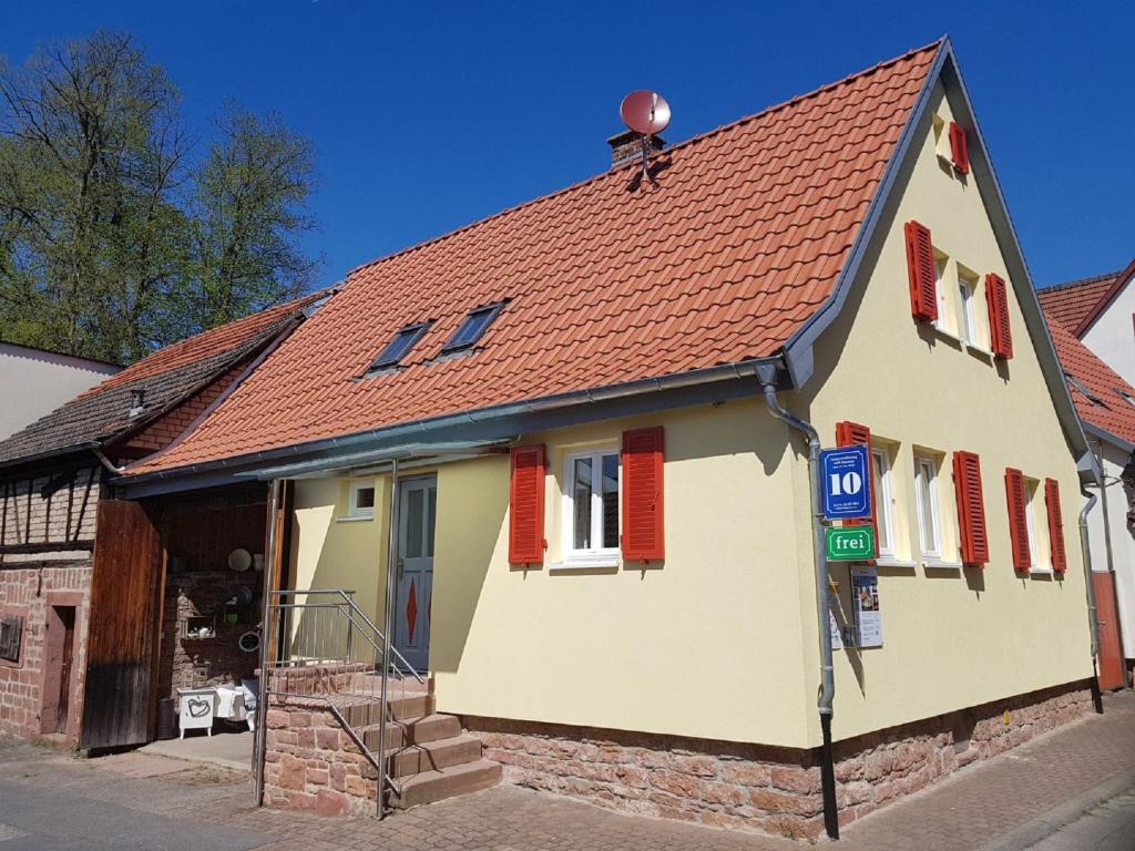 a white house with red shuttered windows and a parking meter at Ferienhaus Nr. 10 in Buergstadt