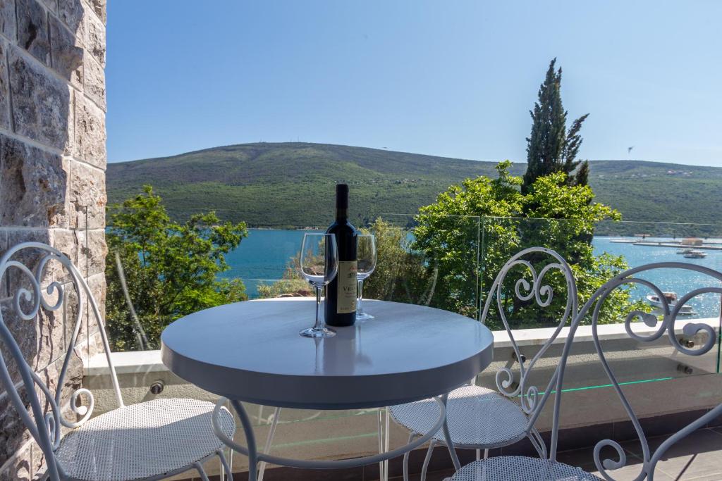 a table with a bottle of wine and two glasses at Riva Residence in Đenovići