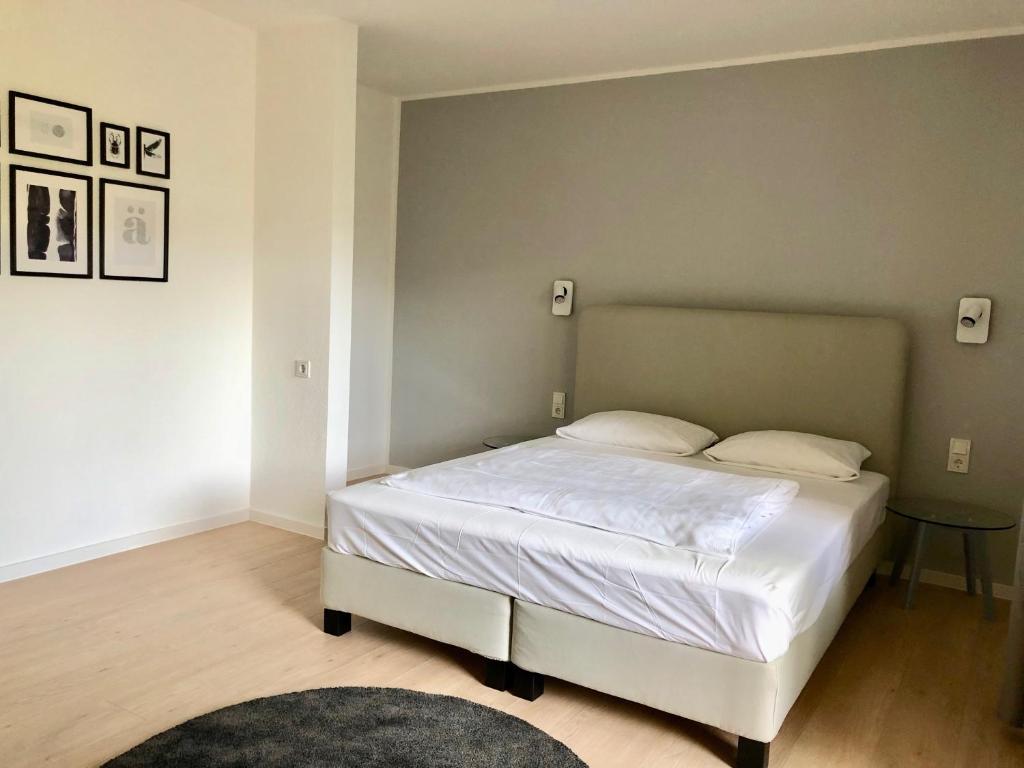 ein Schlafzimmer mit einem weißen Bett in einem Zimmer in der Unterkunft City Hotel und City Apartments Centrum in Kaiserslautern