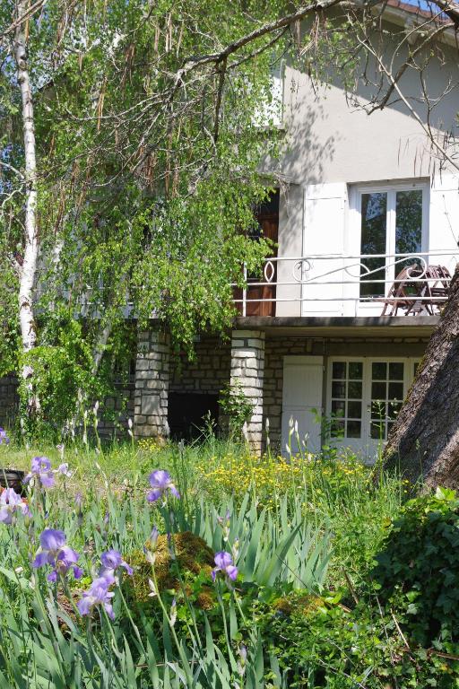 a garden in front of a house with flowers at Au Catalpa in La Chapelle-Faucher