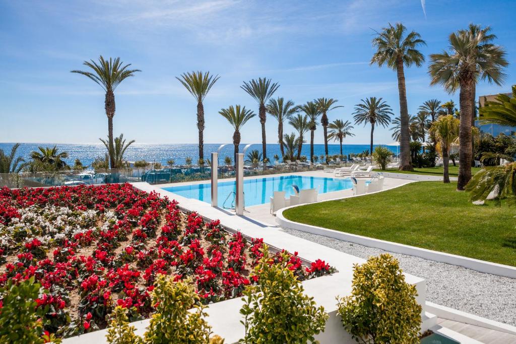 a beach with palm trees and palm trees at Miramare The Palace Resort in Sanremo