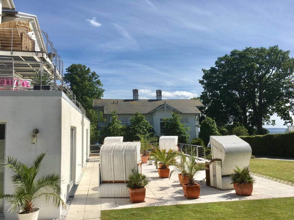 een patio met witte stoelen en potplanten bij Appartement Nr_ 12 im Sonnenbad in Sassnitz