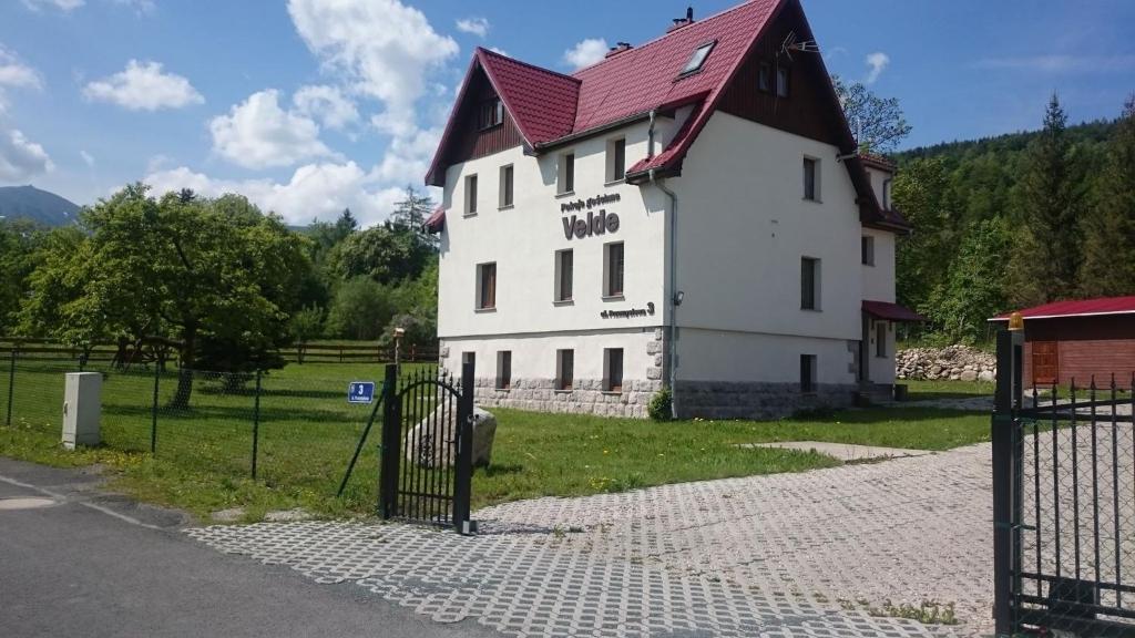 um grande edifício branco com um telhado vermelho em Willa Velde em Karpacz