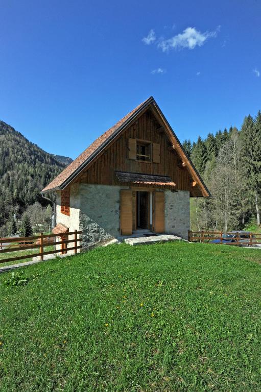 un edificio con un campo de césped delante de él en Albergo Diffuso Ravascletto, en Ravascletto