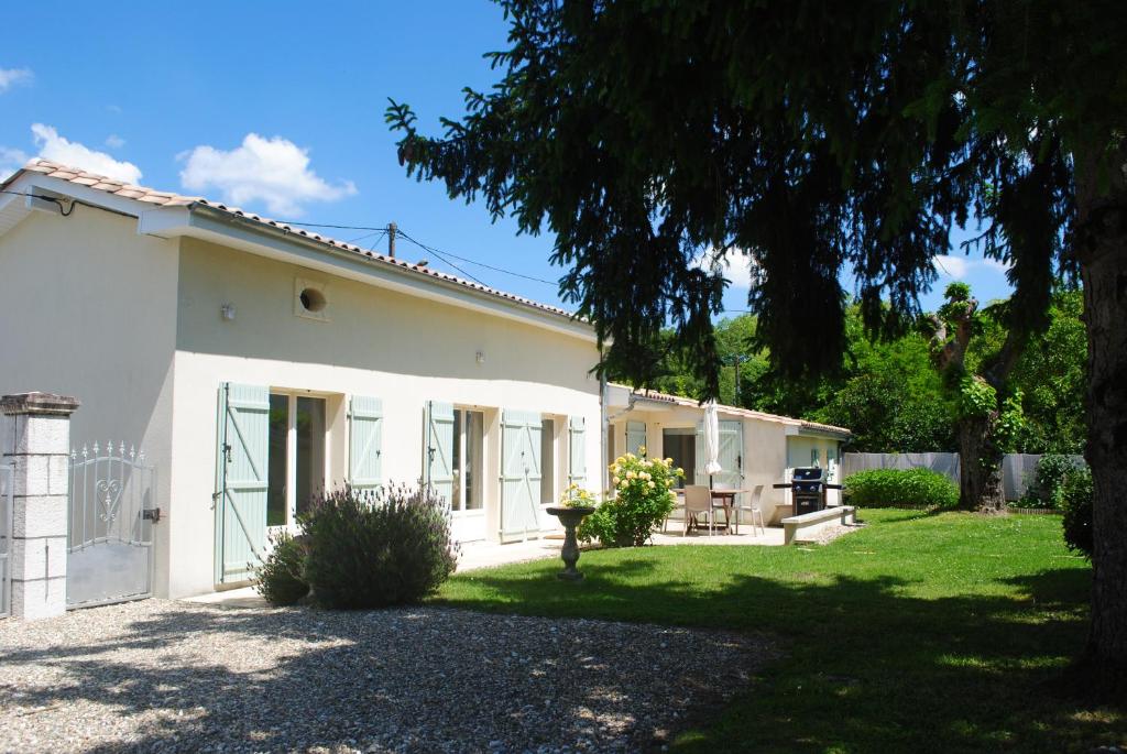 a white house with a yard in front of it at Petit Gite Eymet in Eymet