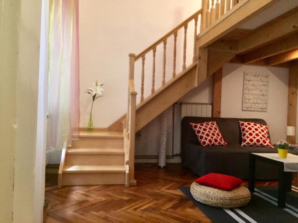een woonkamer met een trap en een bank bij FERJOE'S HOME APARTMAN in Boedapest