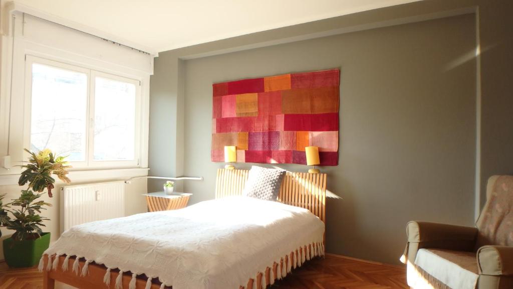 een slaapkamer met een bed en een schilderij aan de muur bij Buda Center in Boedapest