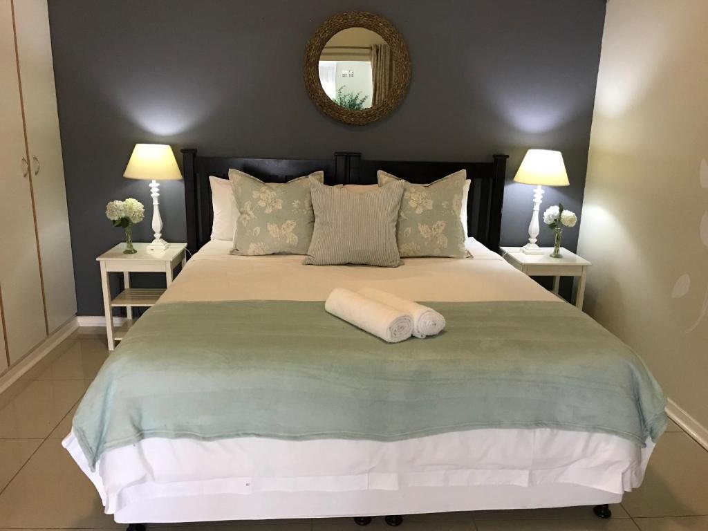 1 dormitorio con 1 cama grande y toalla blanca en Bishops GuestHouse, en Eshowe