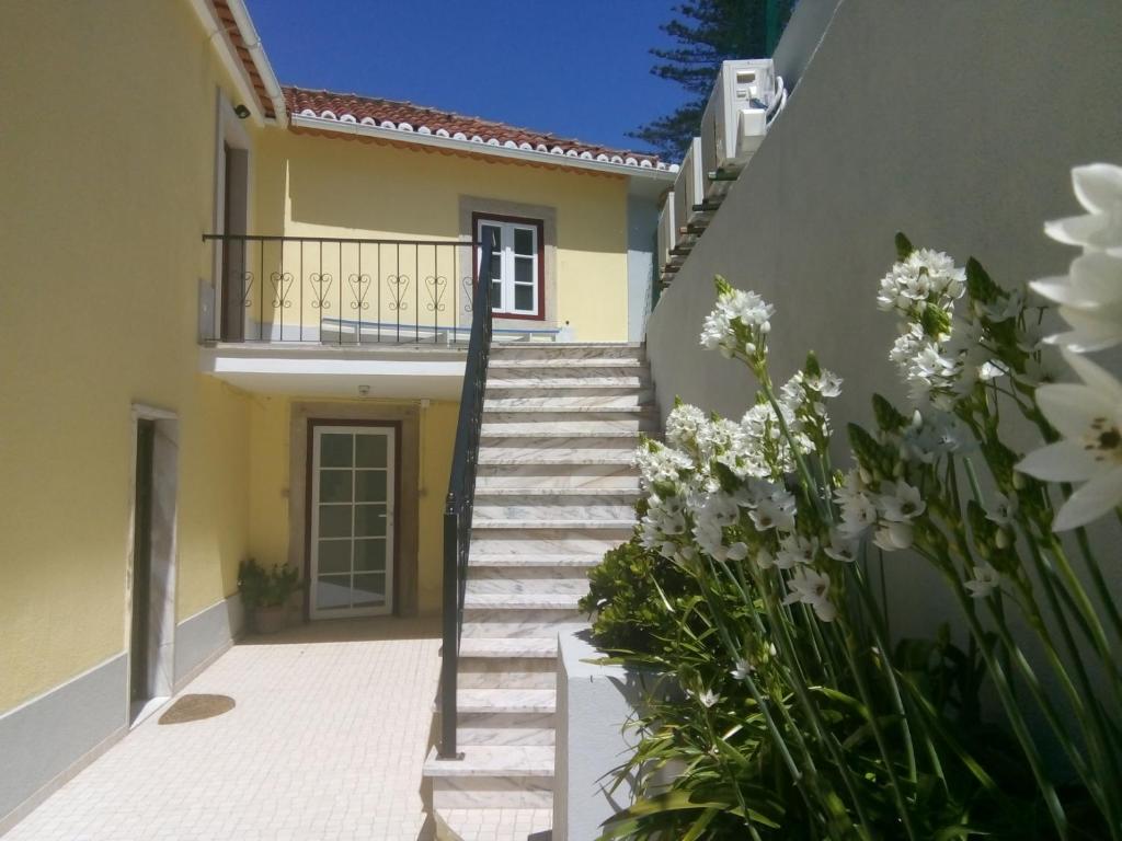 Un escalier mène à une maison fleurie. dans l'établissement Villa in Sintra - Casa da Penha Ferrim, à Sintra