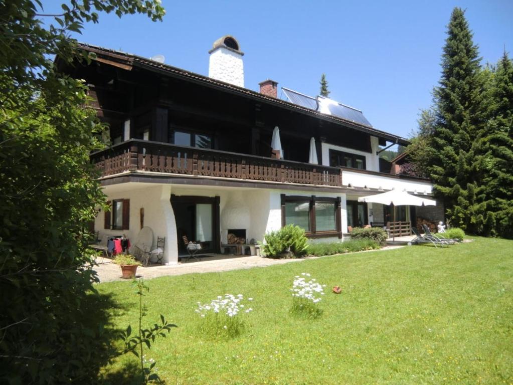 ein großes Haus mit Rasen davor in der Unterkunft Landhaus Kogel in Ofterschwang