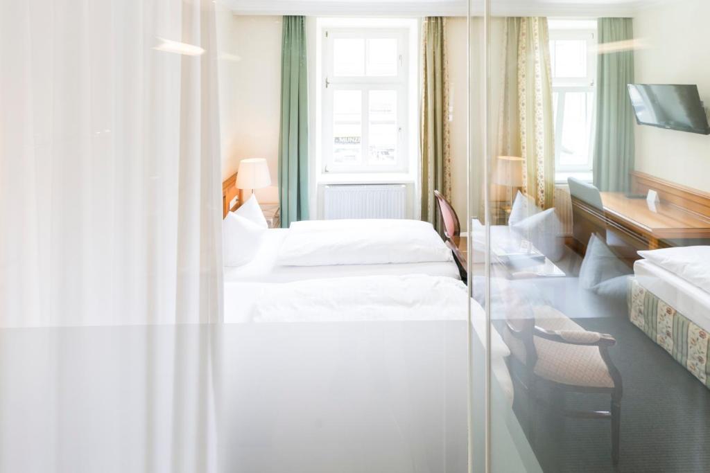 a hotel room with two beds and a window at Hotel Sailer in Innsbruck