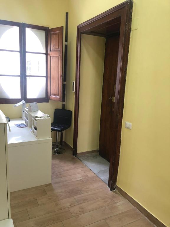 un ufficio con una porta, una scrivania e una finestra di La Casa Di Fafa a Napoli