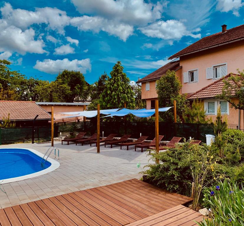 a backyard with a swimming pool and a house at Villa Rubčić Rooms in Rakovica
