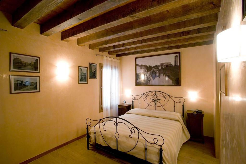 een slaapkamer met een metalen bed in een kamer bij San Cassiano jacuzzi in Venetië