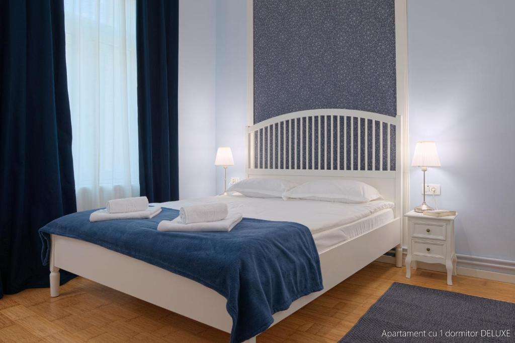 a bedroom with a bed with two towels on it at Republicii Residence in Braşov