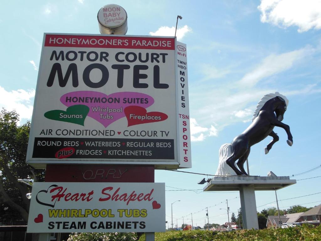una señal para un motel de la pista de automóviles con una estatua en Motor Court Motel en Londres