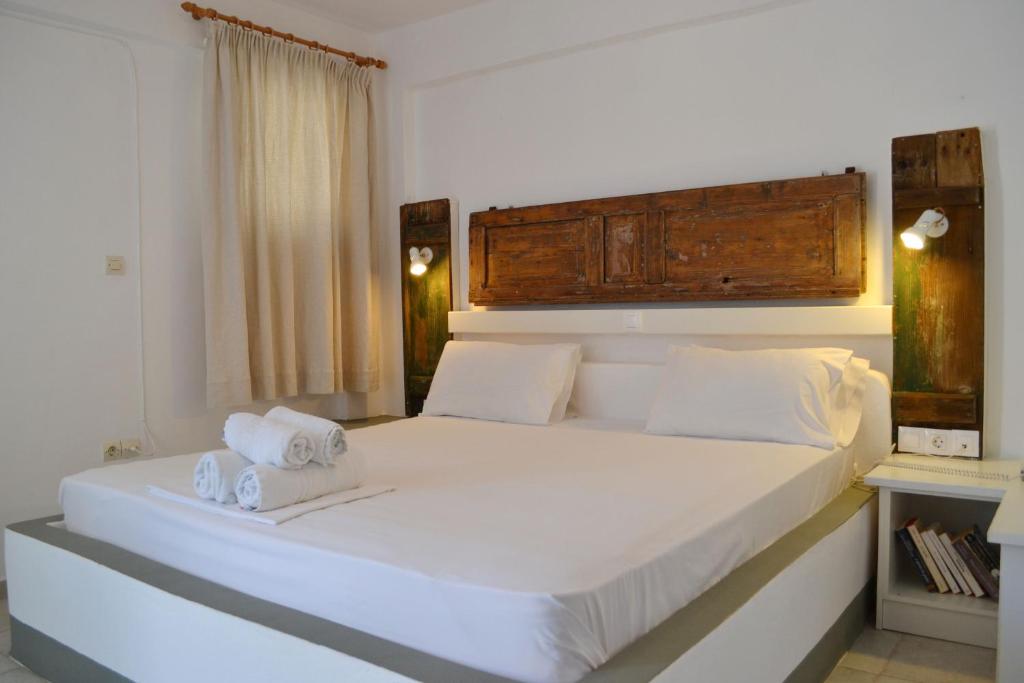 a bedroom with a large white bed with towels on it at Paleochori Studios in Paliochori