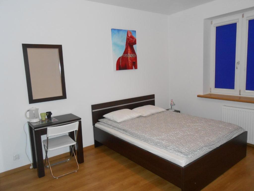 a bedroom with a bed and a table and a mirror at Lux Hostel - z prywatnymi łazienkami in Gdynia