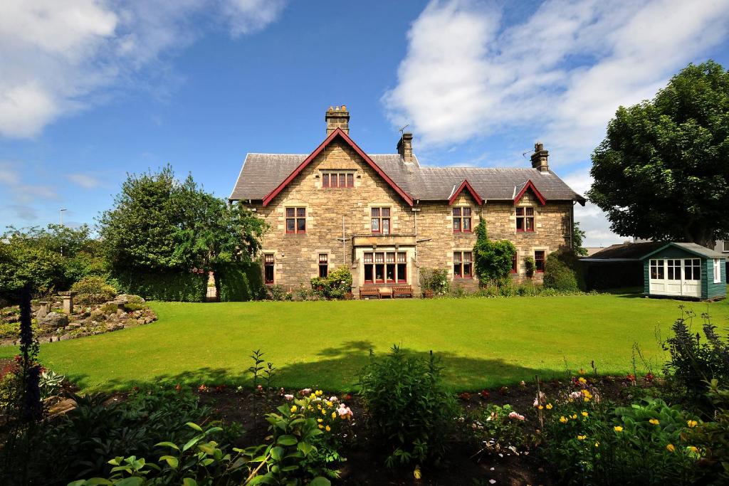 duży ceglany dom z dużym zielonym trawnikiem w obiekcie St Michaels Guest House w mieście Elgin