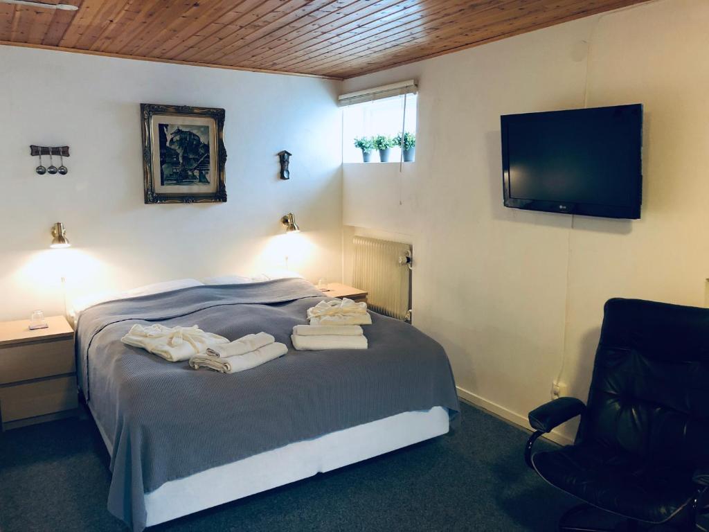 a bedroom with a bed with a television and a chair at Huddinge Studio with Private Entrance in Huddinge