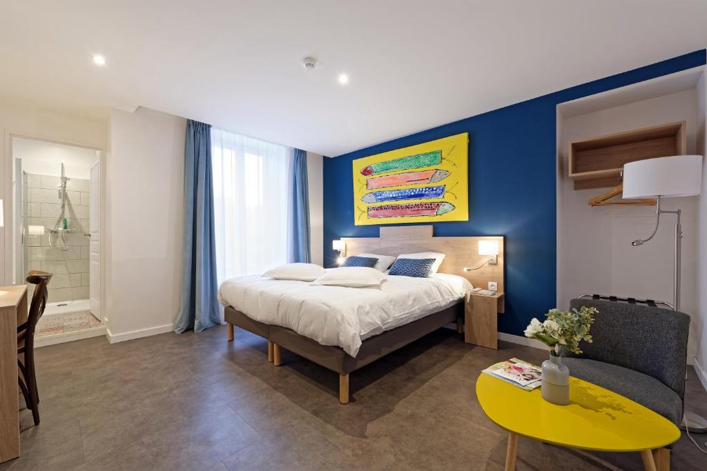 een slaapkamer met een bed en een gele tafel bij Contact Hôtel de la Gare et son restaurant Côte à Côte in Autun