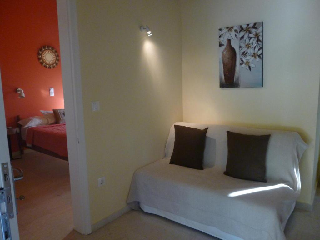 a living room with a white couch with two pillows at Athina Apartments in Arillas