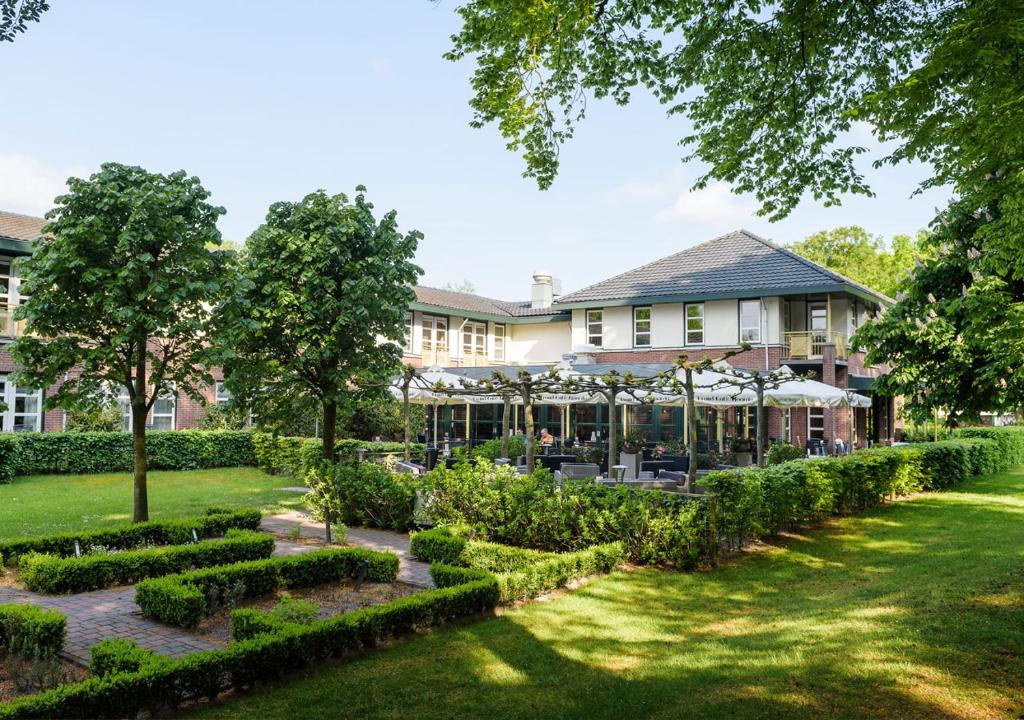 
a large building with a large garden in front of it at Parkhotel Tjaarda in Oranjewoud
