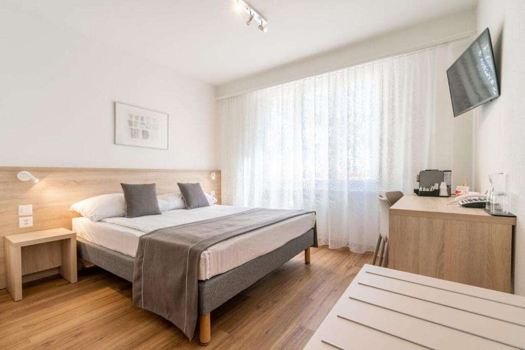 Postel nebo postele na pokoji v ubytování Hôtel Des Arts