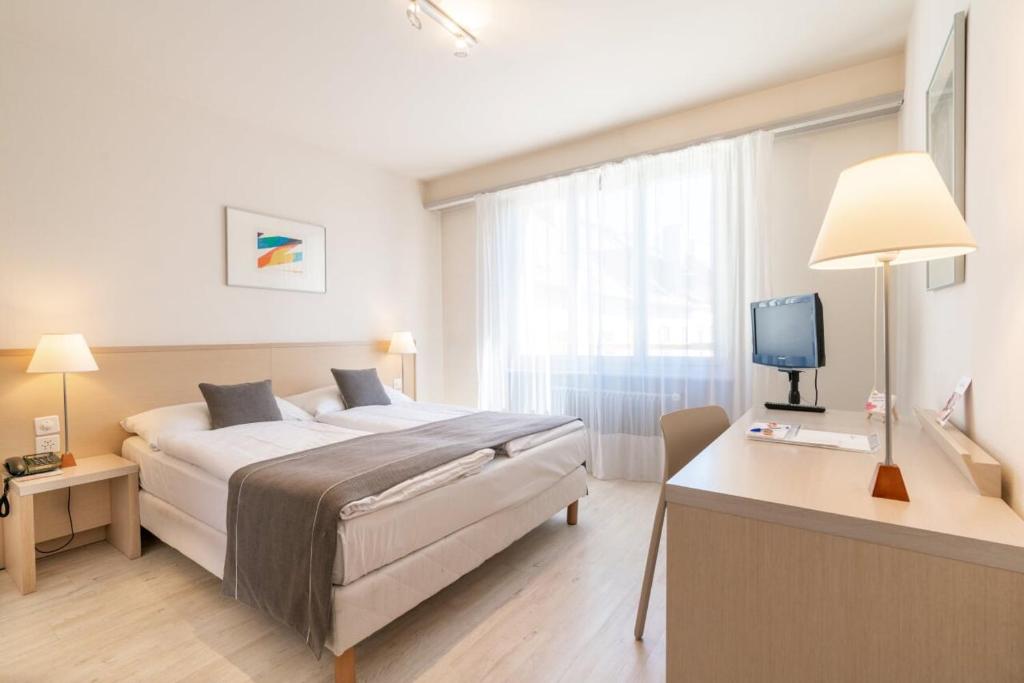 Postel nebo postele na pokoji v ubytování Hôtel Des Arts