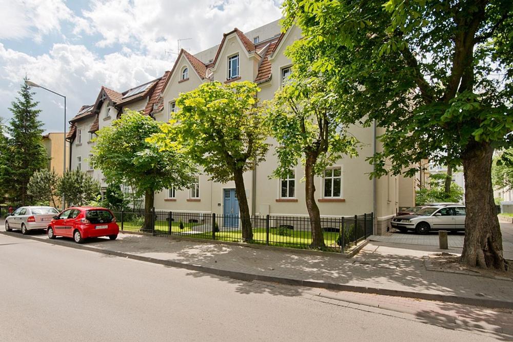 czerwony samochód zaparkowany przed domem w obiekcie Imperial Apartments - Balticana w mieście Sopot