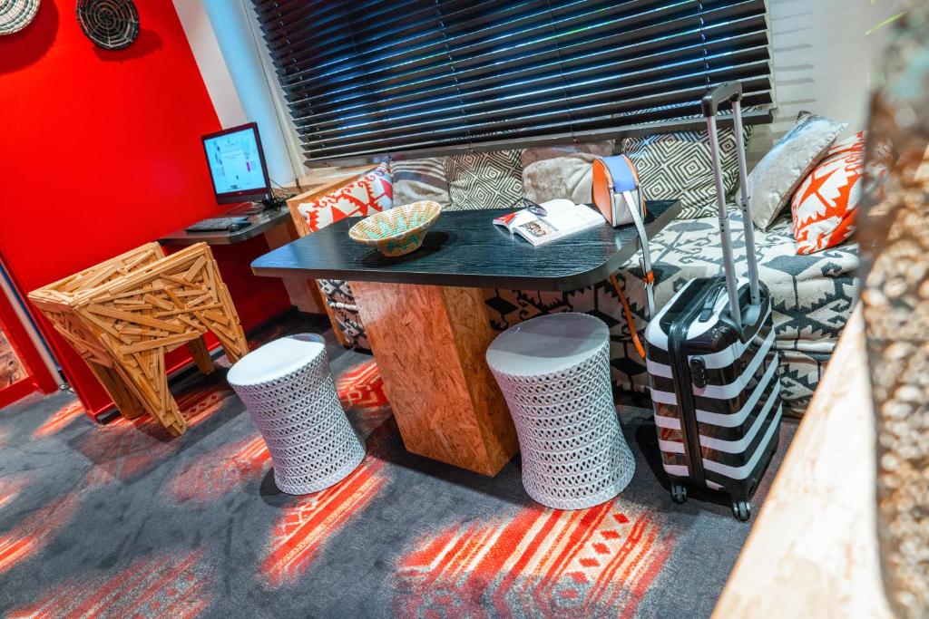 a room with a table and a couch and a desk at ibis Styles Paris Boulogne Marcel Sembat in Boulogne-Billancourt