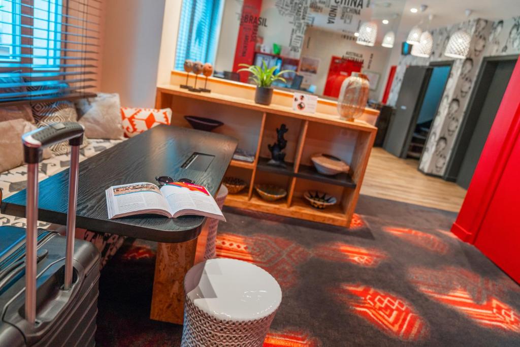a living room with a table with a book on it at ibis Styles Paris Boulogne Marcel Sembat in Boulogne-Billancourt