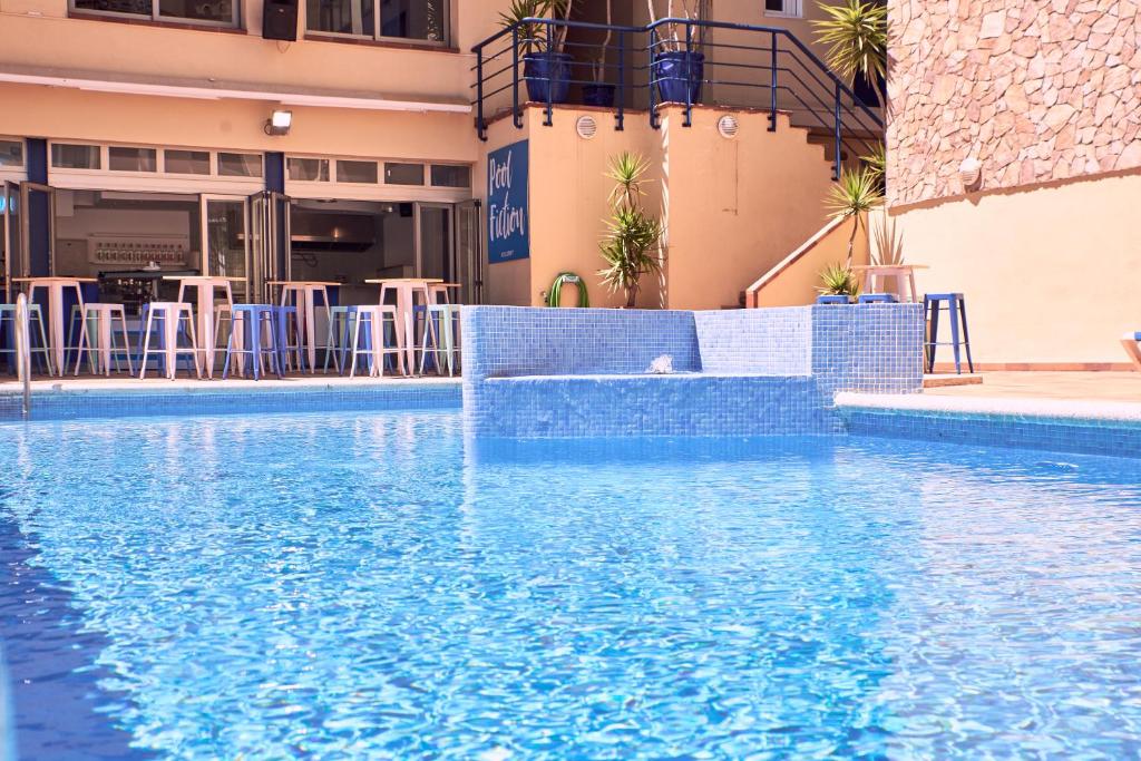 una piscina de agua azul en un hotel en Hotel Caribe, en Lloret de Mar