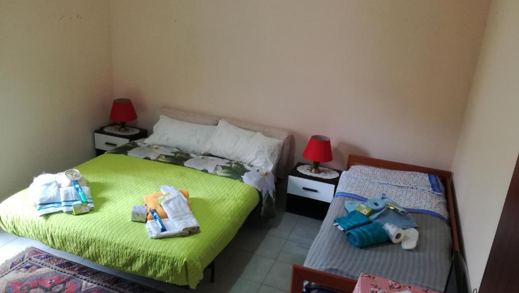 una camera con due letti e asciugamani di B&b Etneo a Belpasso