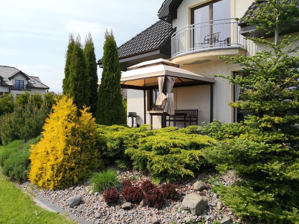 a garden in front of a house with bushes at Rewska Przystań - Dom z balią ogrodową i sauną in Rewa