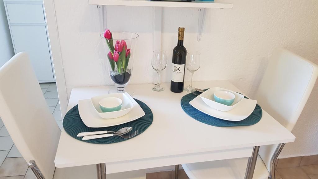 a white table with two hats and a bottle of wine at Apartman Duba in Senj
