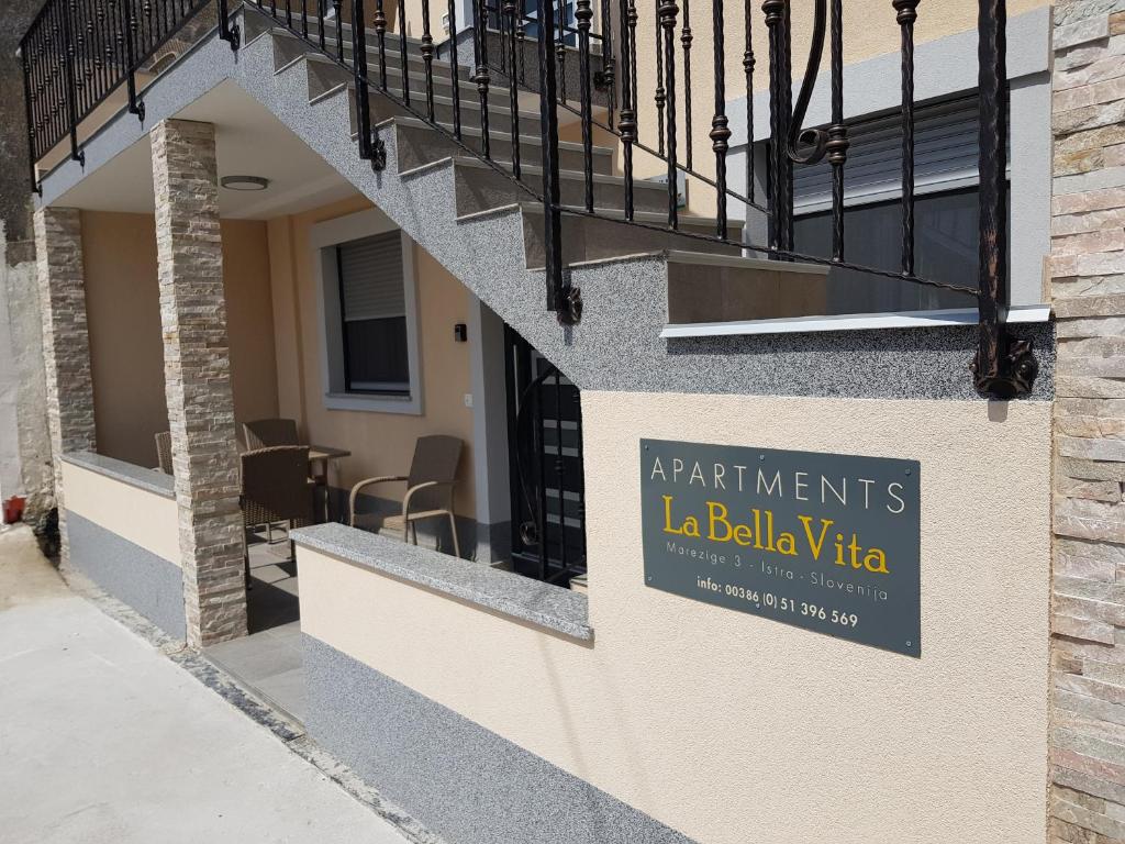 un panneau sur le côté d'un bâtiment qui indique les appartements la bellevia dans l'établissement La Bella Vita Marezige, à Koper