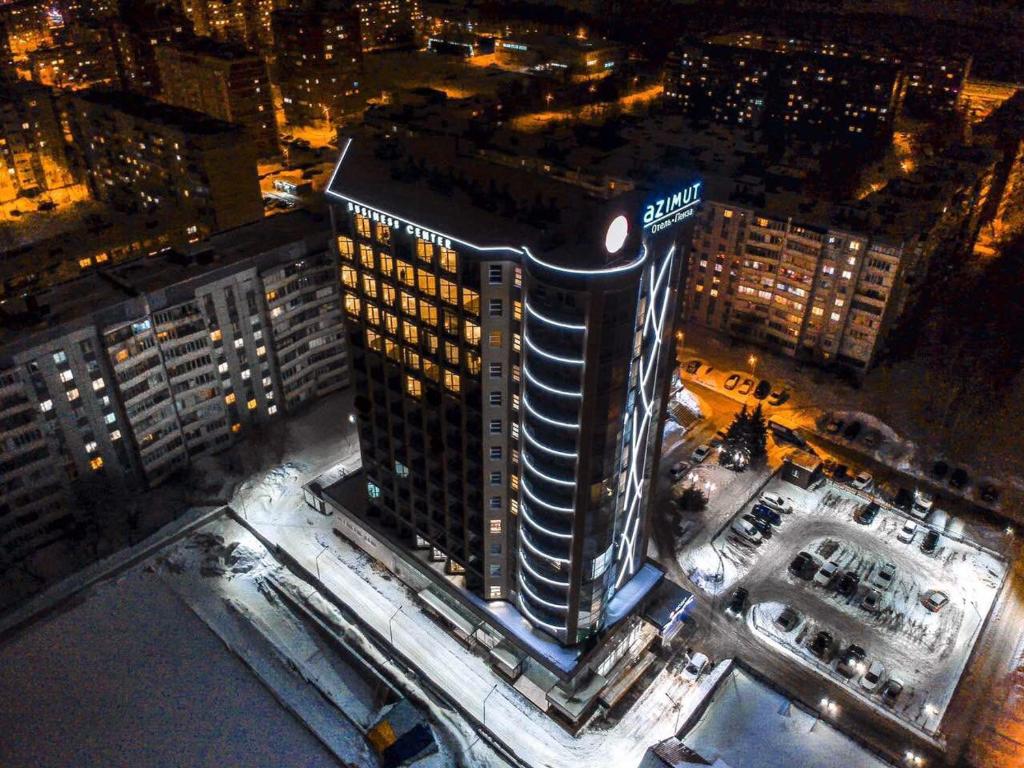 um edifício alto com um cartaz à noite em AZIMUT Hotel Penza em Penza