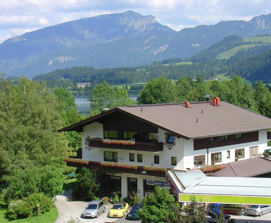 un edificio con coches estacionados frente a él con montañas en Ferienwohnungen Greiderer Walchsee, en Walchsee