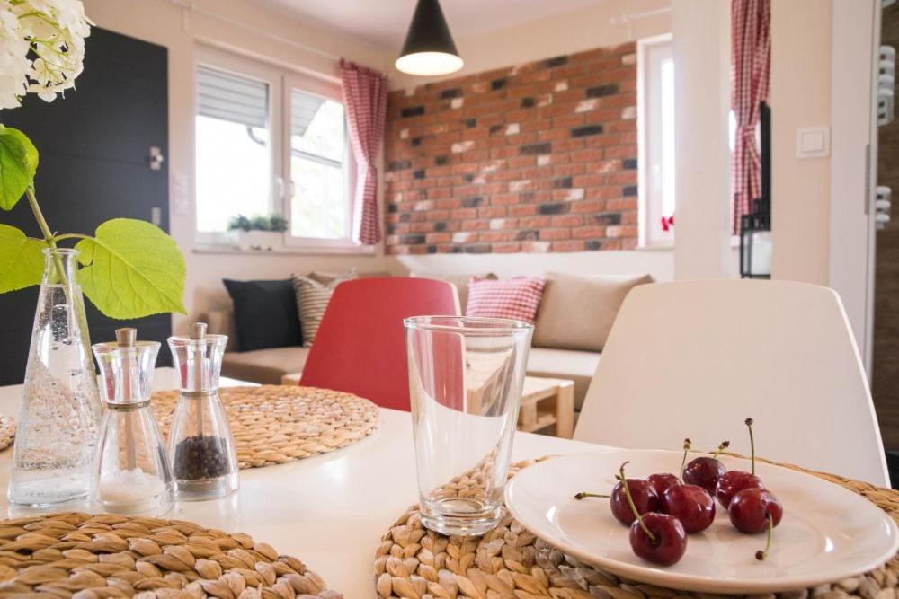 a table with a plate of cherries on it at Piaskowa Polana in Dębki