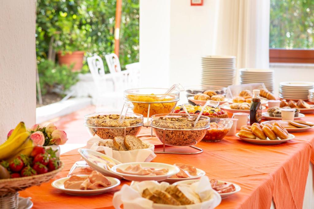 a table topped with bowls of food and other foods at Hotel La Mandorla in Ischia