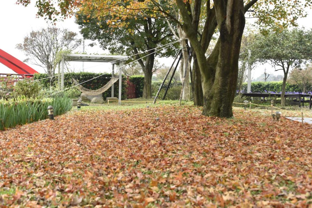 a pile of leaves in a park with a swing at Rainbow Bridge B&amp;B in Sanzhi
