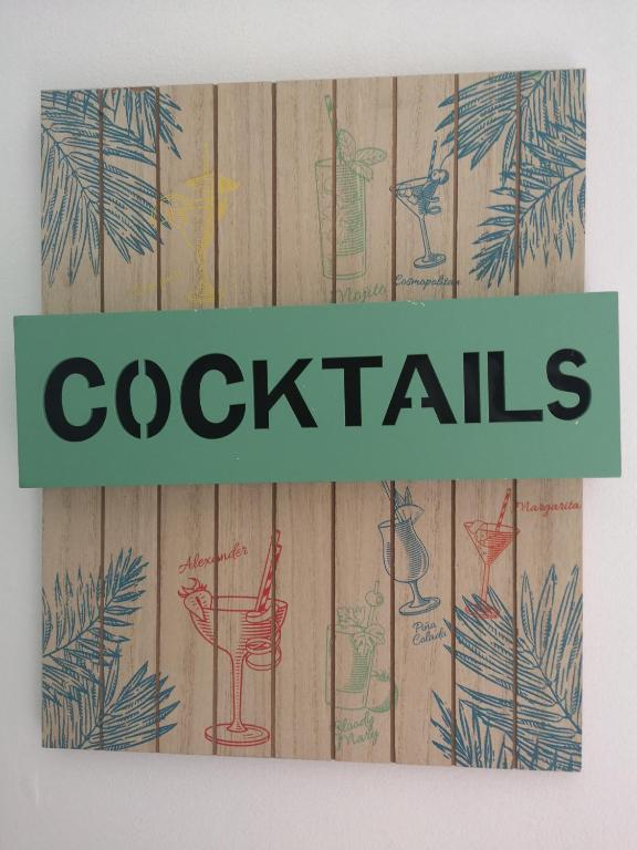 a sign that says cocktails on a wooden fence at La Terrasse Fleurie in Saint-Omer