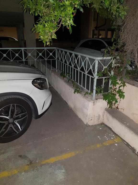 a white car parked next to a fence at Alghero Heart in Alghero
