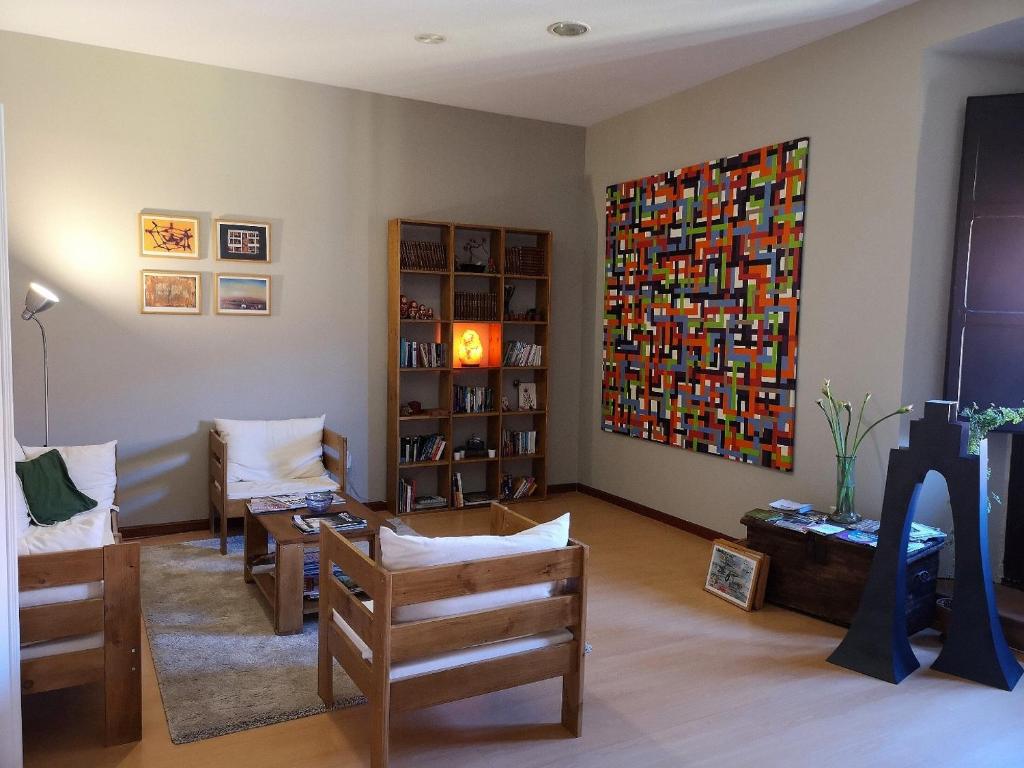 uma sala de estar com cadeiras e uma grande pintura na parede em Hostal San Martin em León