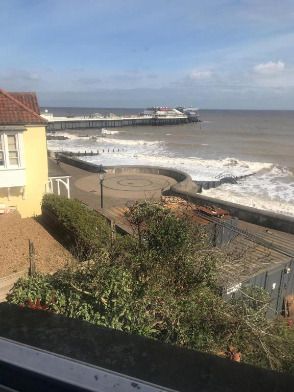 a view of a beach with a pier and the ocean at CROMER FLAT ABDUL in Cromer
