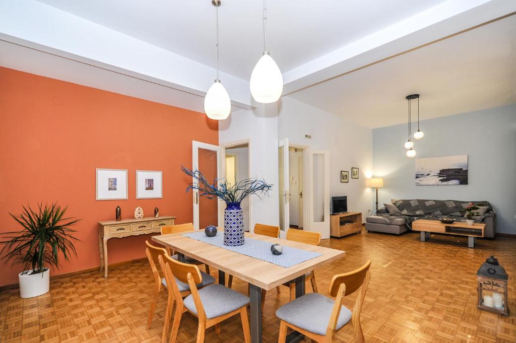 a living room with a table and chairs and a couch at The Elegant. Spacious city center apartment. in Heraklio